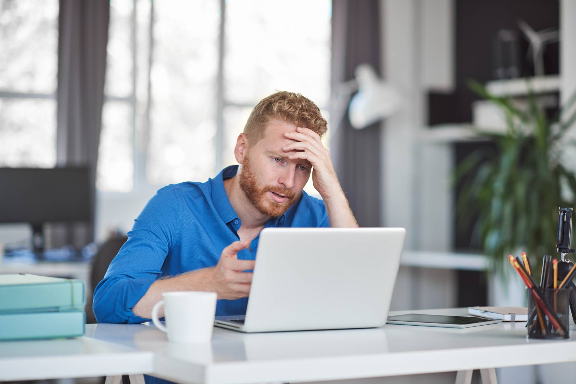 Young serious employee having problems at work. Bad day at work